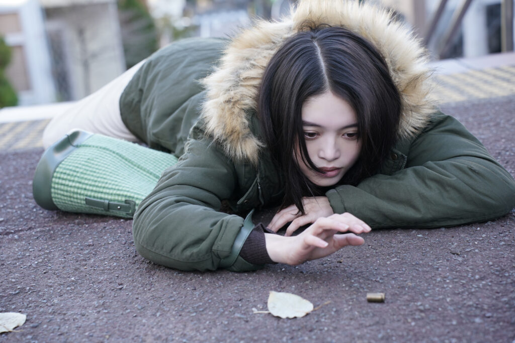 映画「ゴーストキラー」公式X投稿画像（弾を見つめる髙石あかり）